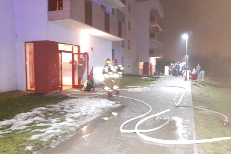 Strażacy gaszą pożar w bloku
