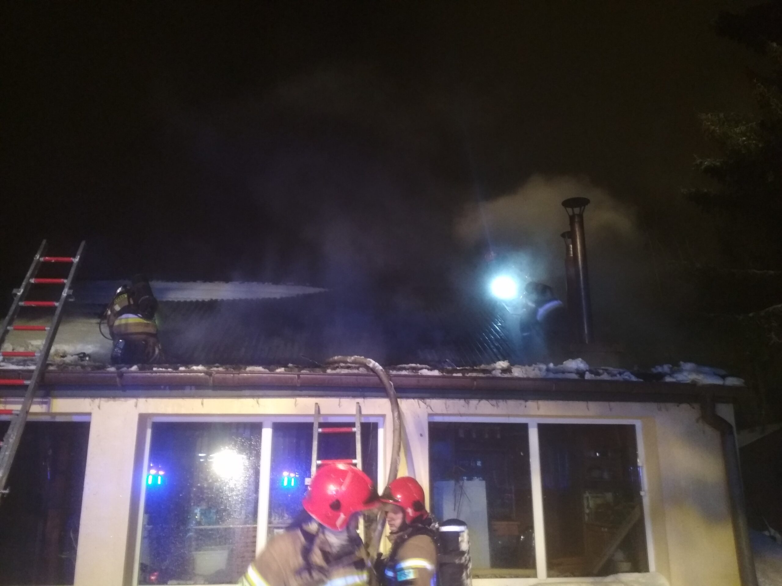 Strażacy gaszą dach budynku