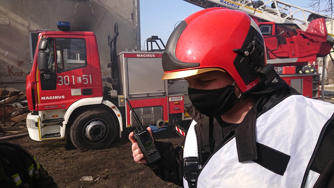 Strażak trzymający w ręku krótkofalówkę