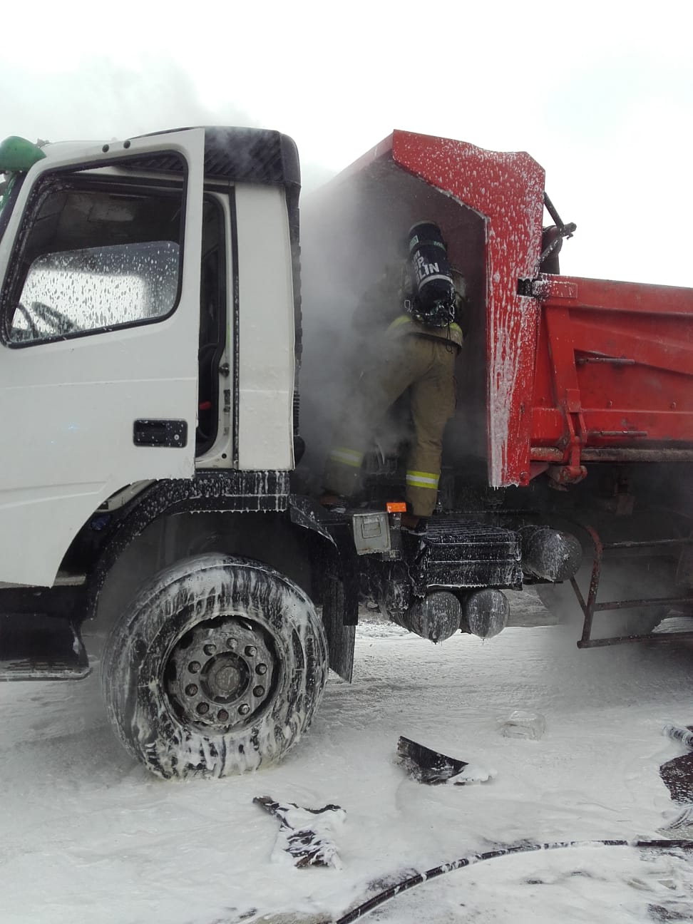 Strażak gaszący pojazd ciężarowy