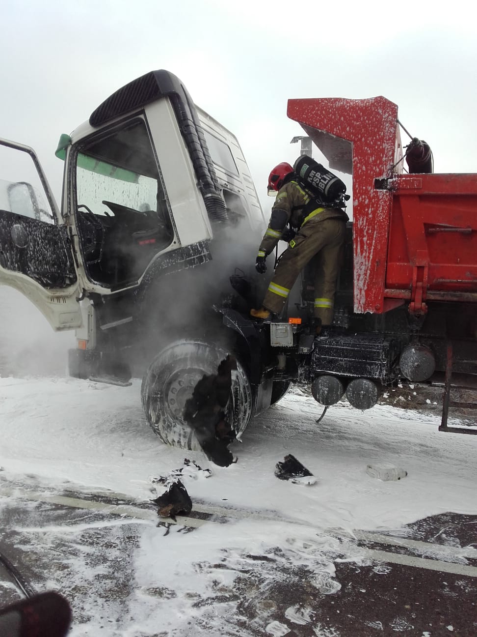 Strażak podczas zabezpieczenia ciężarówki, która uległa pożarowi