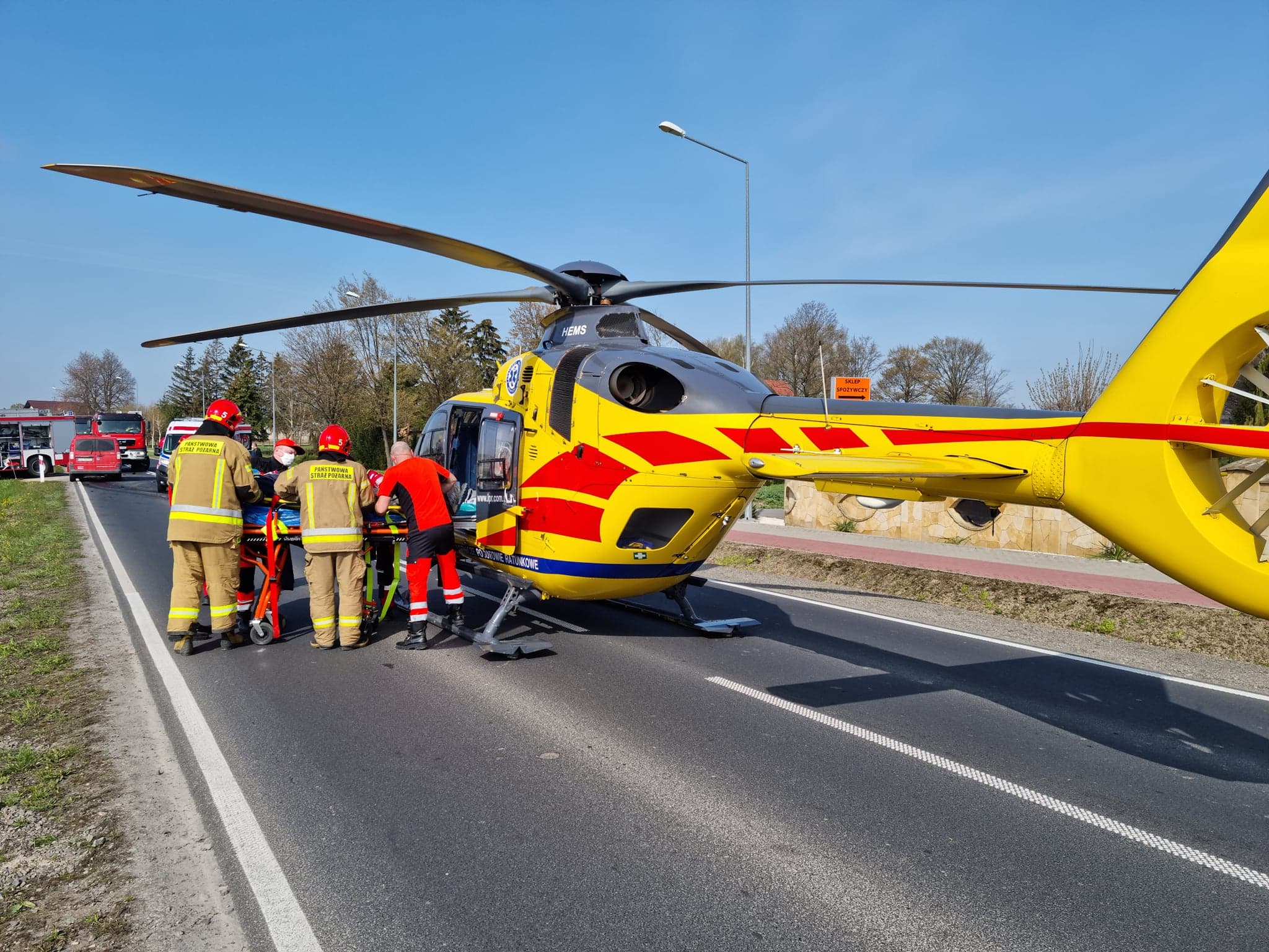 Śmigłowiec pogotowia ratunkowego oraz ratownicy medyczni i strażacy na miejscu wypadku