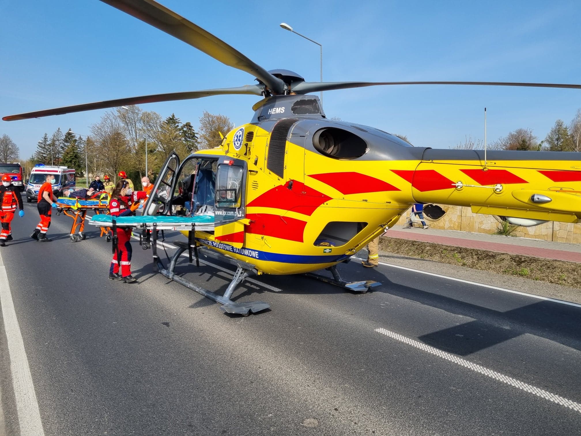 Śmigłowiec pogotowia ratunkowego oraz ratownicy medyczni i strażacy na miejscu wypadku