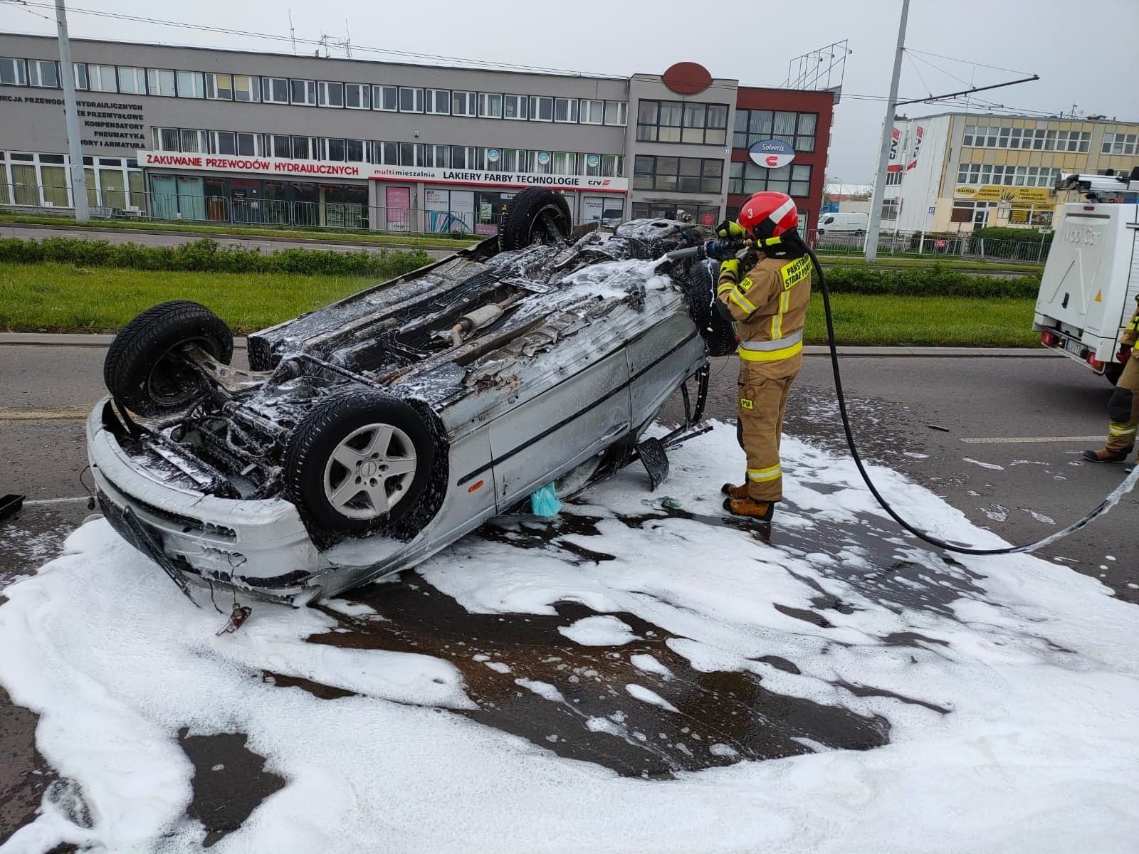 Strażak zabezpieczający auto po wypadku