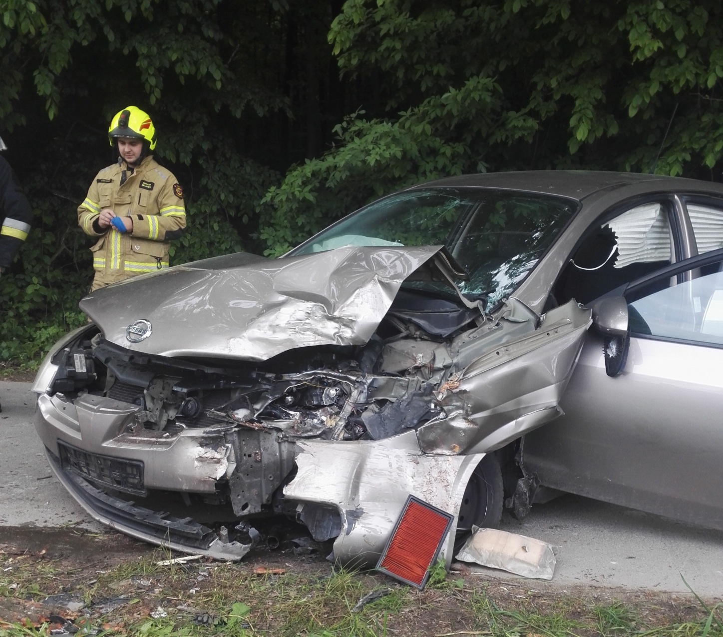 Strażak oraz wrak auta marki Nissan