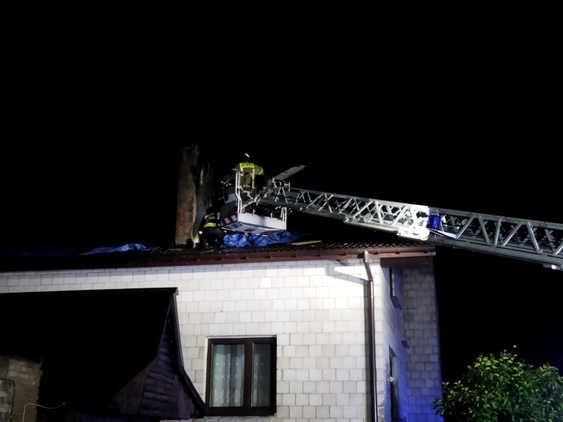 Strażak zabezpieczający komin zniszczony przez nawałnicę