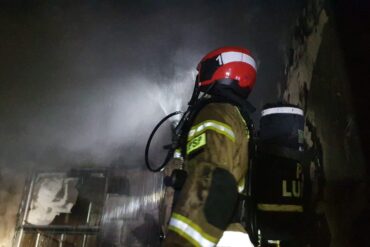 funkcjonariusz podczas gaszenia płonącego budynku